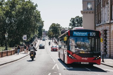 Londra, İngiltere - 1 Ağustos 2018: Kırmızı otobüs rota R70 otobüs Richmond, Güney-Batı Londra'da bulunduğu ve çok sayıda park ve açık alanlar için ünlü Thames Nehri üzerinde bir banliyö şehir sokakta.