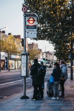 Londra, İngiltere - 24 Temmuz 2018: Larcom Street otobüs durağına Londra'da, İngiltere'de otobüste için bekleyen insanlar. Otobüsler şehrin ulaşım sistemi ayrılmaz bir parçasıdır.