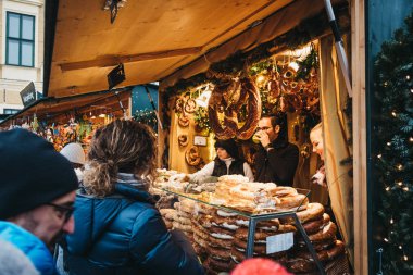Vienna, Avusturya - 25 Kasım 2018: simit Schonbrunn Palace, Avusturya'da en önemli mimari anıtları Noel ve yeni yıl pazarda satışa satın insanlar.