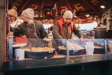 Vienna, Avusturya - 25 Kasım 2018: personel yemek yemek bir stand Noel ve yeni yıl markette Schonbrunn Palace, Avusturya'da en önemli mimari anıtları.