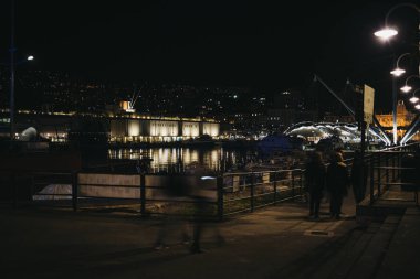 Genoa, İtalya - 30 Ekim 2016: Panoramik liman Cenova, Akdeniz ve gece İtalya'da, liman en büyük Avrupa'nın en büyük şehirlerinden biri. Bulanık hareket insanlar yürüyen geçmiş