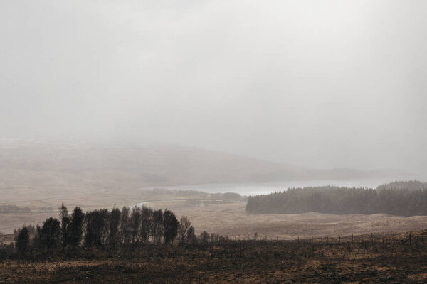 View over Scottish Highlands from the hill on a cold spring snowy day.