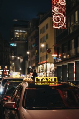 Viyana, Avusturya - 24 Kasım 2018: Viyana, bir sokakta sarı taksi tabelada, geceleri kapatın. Taksiler yerli halk ve turistler için şehir etrafında almak için popüler bir yoldur.