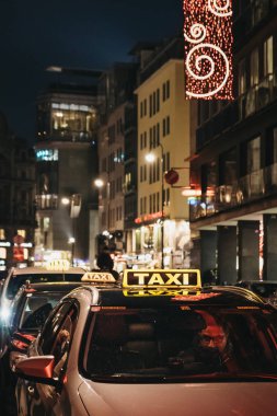 Viyana, Avusturya - 24 Kasım 2018: Viyana, bir sokakta sarı taksi tabelada, geceleri kapatın. Taksiler yerli halk ve turistler için şehir etrafında almak için popüler bir yoldur.