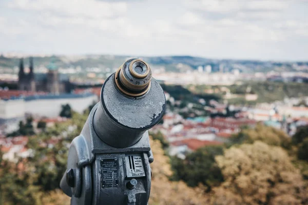 Coin operated binoculars on the viewing platform on Petrin Tower, Prague, in summer, the blurred city background.