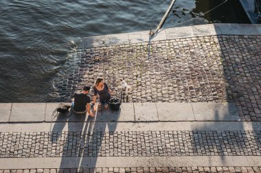 Prague, Çek Cumhuriyeti - 23 Ağustos 2018: bir sıcak yaz günü Prag'da Vltava Nehri'nin dolgu üzerinde oturan insanlar. Vltava Çek Cumhuriyeti içinde en uzun nehridir.