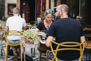 Prague, Çek Cumhuriyeti - 23 Ağustos 2018: insanlar Prag bir restoranda açık masalarında bira içiyor. Bira çek kültürünün büyük bir parçasıdır ve Prag'da çok sayıda bira vardır.