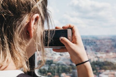 Prague, Çek Cumhuriyeti - 26 Ağustos 2018: kadın çekim Smartphone'da Petrin Kulesi, Prag, popüler bir turizm Petrin tepenin üstüne şehrin güzel manzaralarını sunuyor.
