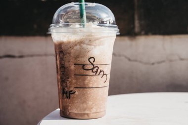 Prag, Çek Cumhuriyeti - 26 Ağustos 2018: Starbucks buzlu kahve açık bir tablo üzerinde ismi Sam şeffaf plastik kap içinde krem ile yaz aylarında. Ünlü Amerikan Kahvesi zinciri Starbucks olduğunu.