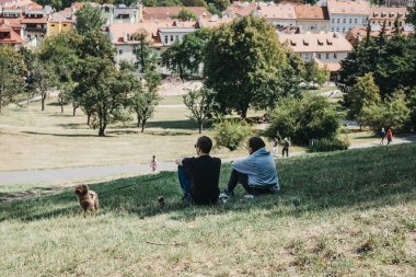 Prague, Çek Cumhuriyeti - 26 Ağustos 2018: oturmuş, Petrin Hill, eski bir Kral Charles üzüm bağları ve turistler ve yerliler için popüler bir yer Prag'dan manzarayı iki kişi.