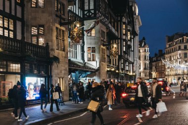 Londra, İngiltere - 05 Ocak 2019: İnsanlar ve araçların önünde özgürlük alışveriş merkezinde Oxford Circus, Londra, akşam. 1875 yılında açıldı, lüks mallar ve klasik özgürlük tasarımları ünlü.