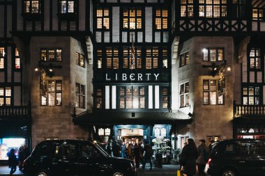 Londra, İngiltere - 05 Ocak 2019: İnsanlar ve araçların önünde özgürlük alışveriş merkezinde Oxford Circus, Londra, akşam. 1875 yılında açıldı, lüks mallar ve klasik özgürlük tasarımları ünlü.
