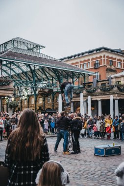 Londra, İngiltere - 5 Ocak 2019: kalabalık izlerken sokak sanatçı Covent Garden Market, Londra, İngiltere'de en popüler turistik yerleri önünde gerçekleştirme.