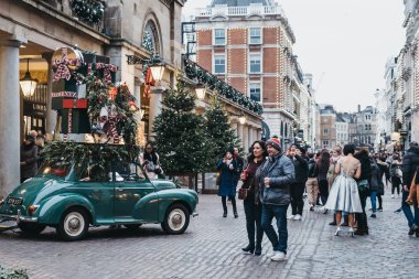 Londra, İngiltere - 21 Kasım 2018: geçmiş yürüyüş ve Covent Garden pazarında, Londra, İngiltere'de en popüler turistik yerleri Noel süslemeleri bir araba fotoğrafını çekmek insanlar.