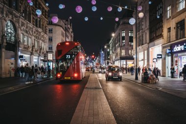 Londra, İngiltere - 05 Ocak 2019: Çift katlı kırmızı otobüs, siyah kabinler ve insanlar yeni Oxford Street üzerindeki Noel ışıkları ile dekore edilmiştir. Yeni Oxford Street Londra, İngiltere'de ünlü bir alışveriş caddesi olan.