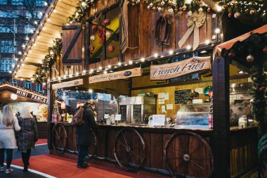 Londra, İngiltere - 21 Kasım 2018: Pazar Leicester Meydanı'nda açılan Noel içinde insanlar gıda tarafından stand. Leicester Square Londra dükkanlar dolu bir ünlü turistik bölgedir.