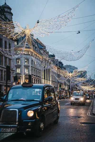 ロンドン イギリス 2019 黒タクシー天使の下でクリスマス ライト リージェント ストリートの夕方には モーション ブラー リージェント — ストック写真