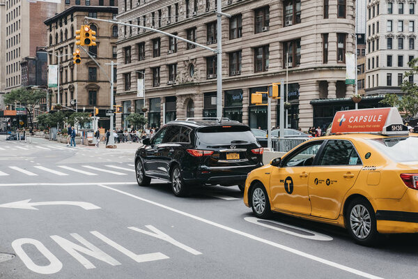New York, USA - May 30, 2018: Car and yellow taxi waiting on traffic light on street in Manhattan New York, USA. New York is the third most traffic congested city in the world.
