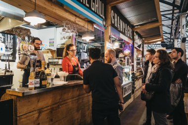 London, UK - January 13, 2019: People inside Mercato Metropolitano, the first sustainable community market in London focused on revitalising the area and protecting environment.