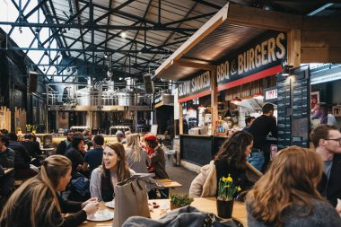 Londra, İngiltere - 13 Ocak 2019: Alan canlandırılarak ve çevreyi koruma Mercato Metropolitano Barbekü ve burger standında kişilerce, Londra'da ilk sürdürülebilir toplumsal pazar odaklı.