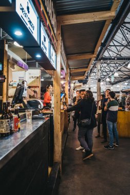 London, UK - January 13, 2019: People inside Mercato Metropolitano, the first sustainable community market in London focused on revitalising the area and protecting environment.