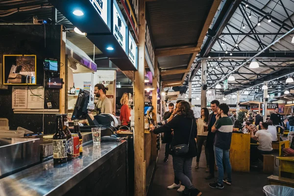 London, UK - January 13, 2019: People inside Mercato Metropolitano, the first sustainable community market in London focused on revitalising the area and protecting environment.