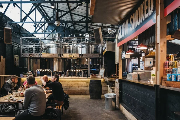 Londra, İngiltere - 13 Ocak 2019: Alan canlandırılarak ve çevreyi koruma Mercato Metropolitano Barbekü ve burger standında kişilerce, Londra'da ilk sürdürülebilir toplumsal pazar odaklı.