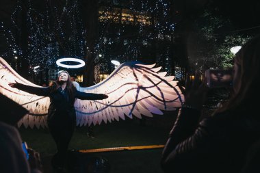 Londra, İngiltere-Ocak 26, 2019: kadın kış ışıklar, yıllık ışıklar ve Canary Wharf teçhizatları Festivali Fotoğraf için poz. Canary Wharf bir meşgul mali kez olayları barındıran Londra alandır.