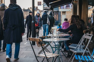 Londra, İngiltere - 03 Şubat 2019: Broadway Market, Hackney, Londra, İngiltere, kalbinde bir alışveriş caddesi üzerinde bir açık bir kafede masada oturan insanlar.