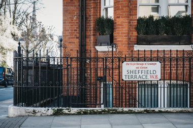 Sheffield Terrace street name sign on a black fence, Kensington  clipart