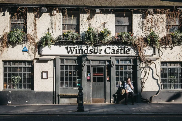 Woman smoking outside Windsor Castle pub in Holland Park, London — Stock Photo, Image