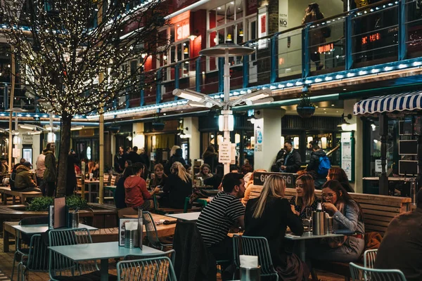 Menschen, die an den Tischen im Freien des königlichen Hofes sitzen, London, Großbritannien — Stockfoto