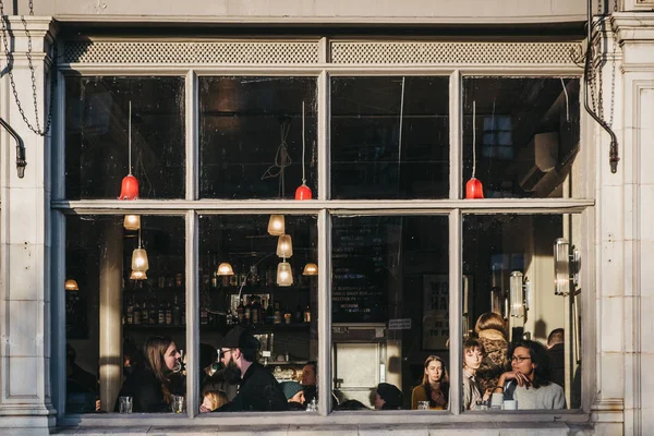 从布拉市场咖啡馆酒吧内的人群窗口可以看到 — 图库照片