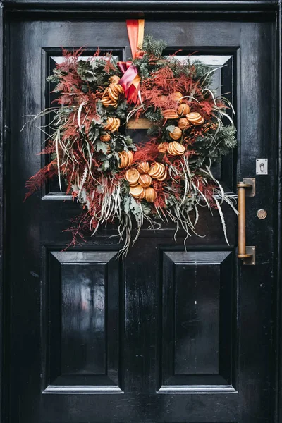 Puerta negra con una decoración floral otoñal en una E tradicional —  Fotos de Stock