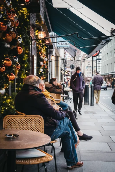 Ludzie siedzący przy stołach zewnątrz kawiarni w Covent Garden, Lon — Zdjęcie stockowe