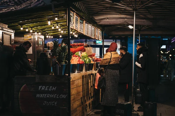 Gente comprando frutas y jugos frescos en el puesto de Juicebox en Oxf — Foto de Stock