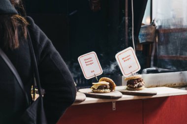 Onun için bir oryantal yiyecek stand Greenwich içinde bekleyen kadın