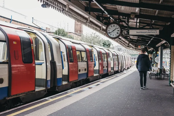 People walking past the train on the outdoor platform of Golders — Stock Photo, Image