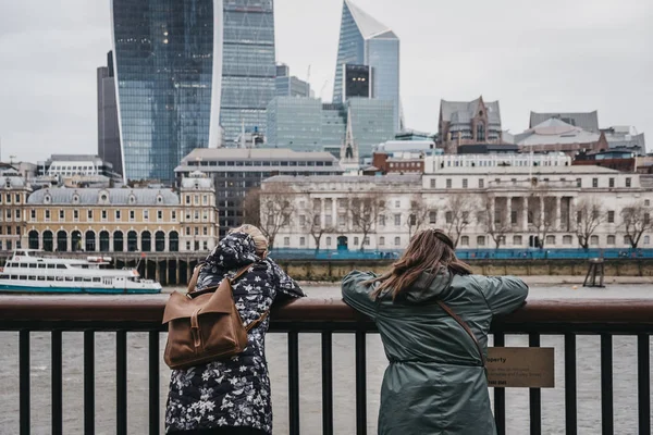 Two female tourists standing by the River Thames, London, UK, le — Stock Photo, Image