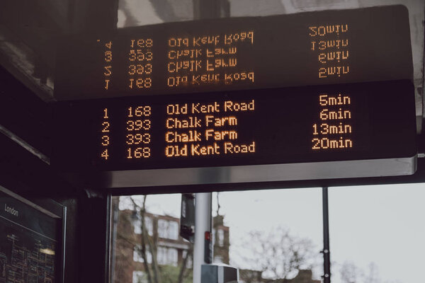 Buses schedule on digital screen on a bus stop in London, UK.