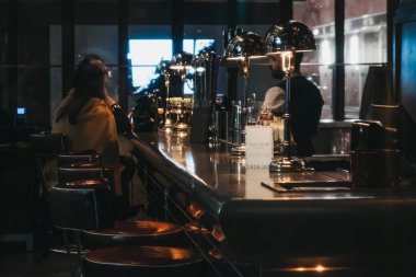 Canary Wharf, Londra, İngiltere'de bir barda içinde oturan insanlar.