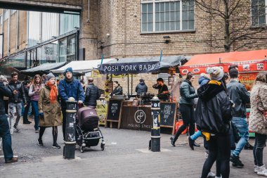 Brick Lane, Londra, Ingiltere üzerinde gıda tezgahları geçmiş yürüyüş insanlar.