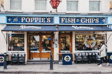 İnsanlar Spitalfields içinde Poppie 's balık ve cips dükkanı geçmiş yürüyüş