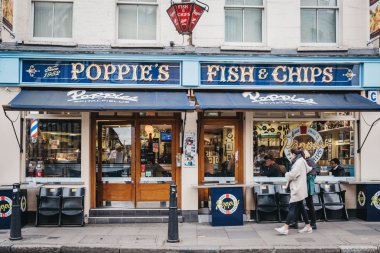 İnsanlar Spitalfields içinde Poppie 's balık ve cips dükkanı geçmiş yürüyüş