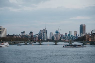 Thames Nehri üzerinde Thames Clipper, arka planda Londra silueti