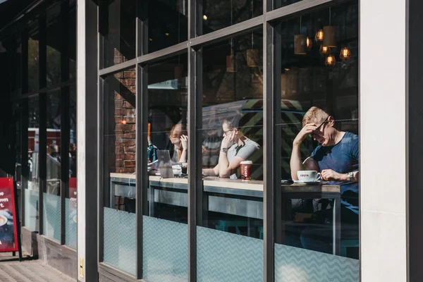 Blick durch das Fenster von Menschen im Costa-Kaffee in London, — Stockfoto