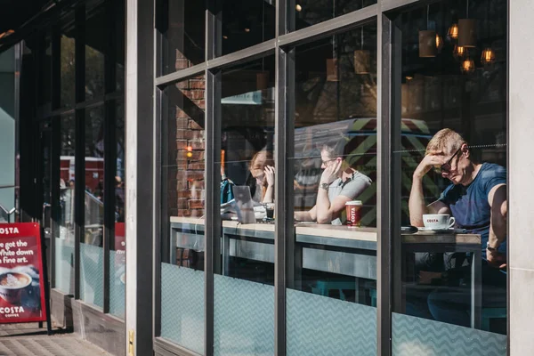 Vista através da janela de pessoas dentro de Costa Coffee em Londres , — Fotografia de Stock