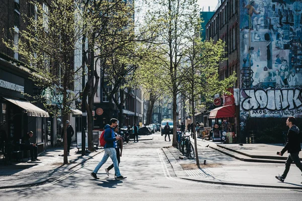 Menschen, die auf der Tottenham Court Road, London, Großbritannien, an einem sonnigen — Stockfoto