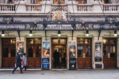 Londra'nın West End'inde Majesteleri Tiyatrosu'nun önünden yürüyen insanlar, Birleşik Krallık.