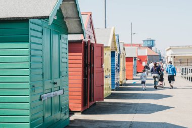 Sheringham, Norfolk, İngiltere, peop deniz tarafından renkli plaj kulübeleri